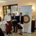 Il Delegato consegna i fiori alla signora ed il piatto al cuoco